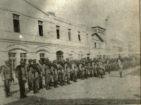 Homens em fila, em frente a um prédio