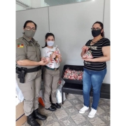 menina parceira da BM com material para doação