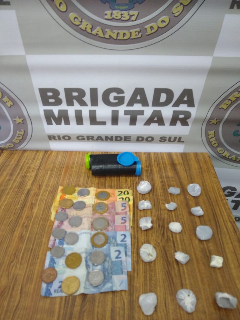 drogas, dinheiro, celular, banner institucional da Brigada Militar