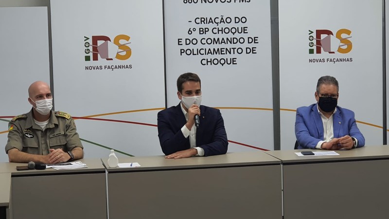 Da esquerda para a direta o Comandante-Geral Coronel Mohr, Governador do Eastado Eduardo Leite e Vice-Governador Ranolfo Vieira Junior, sentados em uma mesa.