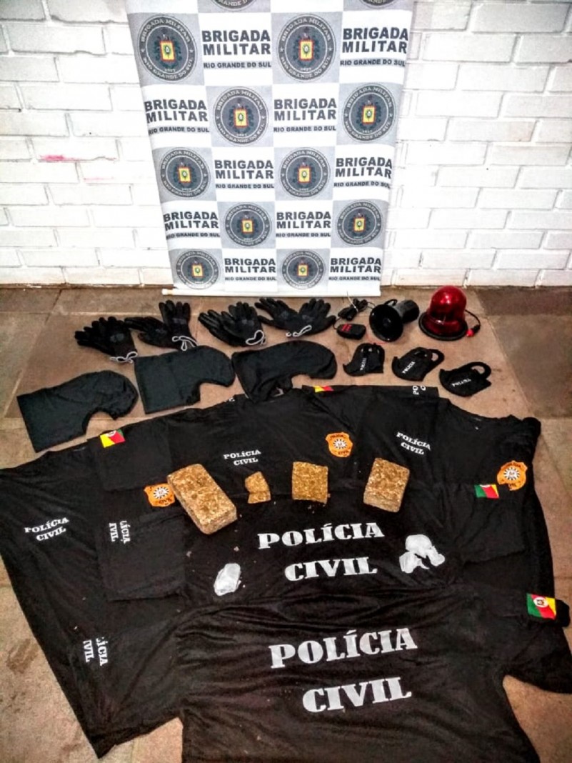 Ao fundo o banner da Brigada Militar, e na frente os materiais apreendidos.
