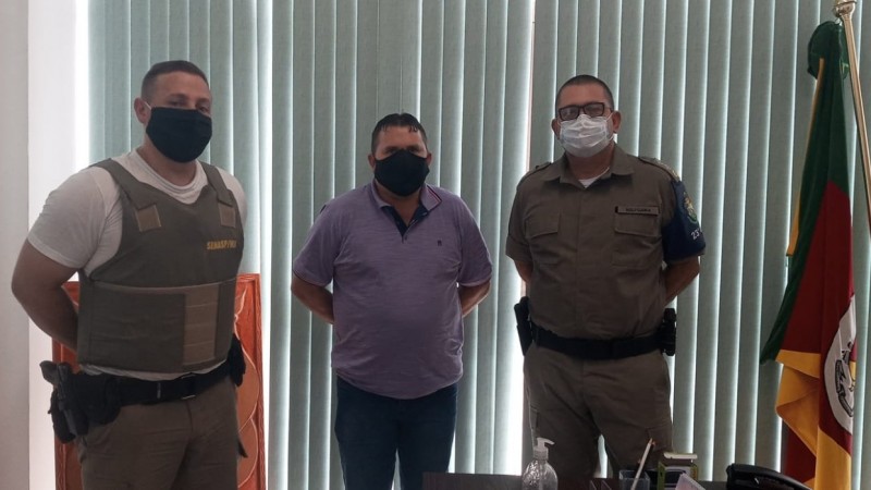 Policiais Militares fardados e o prefeito do munic&iacute;pio no centro.