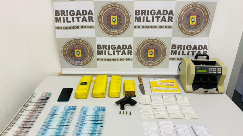 Na imagem aparecem dinheiro, drogas e arma.