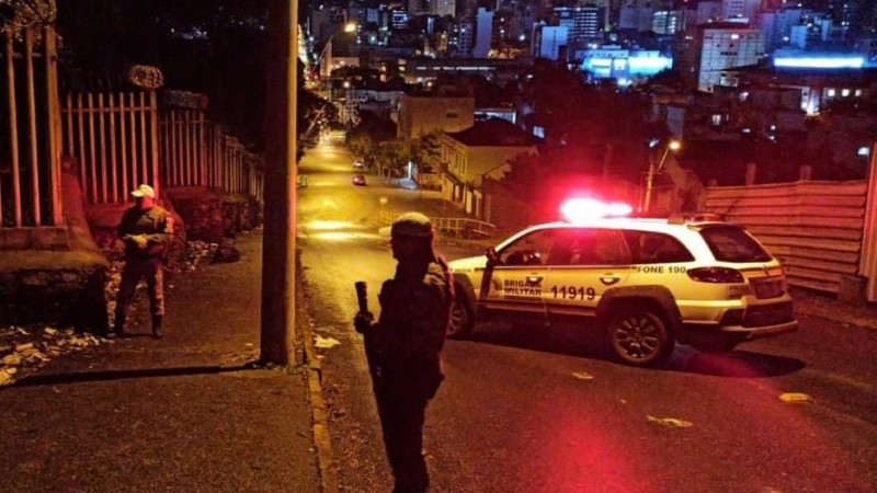 Na imagem aparecem policiais e viatura.