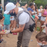 Policial Militar entregando doce para criança
