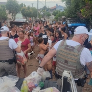 Policial entregando cesta básica para família
