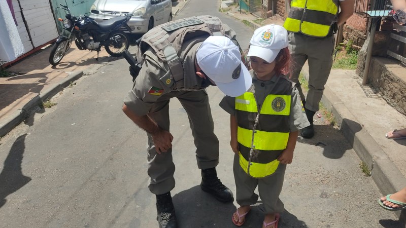 Policial Militar agachado conversando com crian&ccedil;a