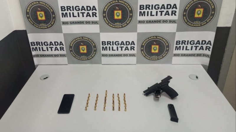 A imagem mostra o material apreendido sobre uma mesa ao fundo o banner institucional da BM