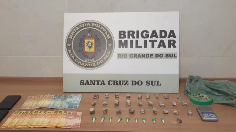 Material apreendido na frente do banner institucional da Brigada Militar.