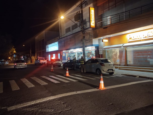 Policiais abordando veículos em barreira policial