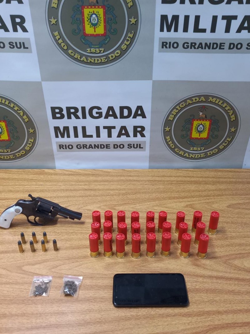 Imagem de um rev&oacute;lver, muni&ccedil;&otilde;es de calibre 12, drogas e um celular apreendidos em Canoas.