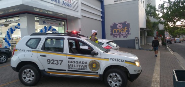 viatura e policial parados em frente a fármacia