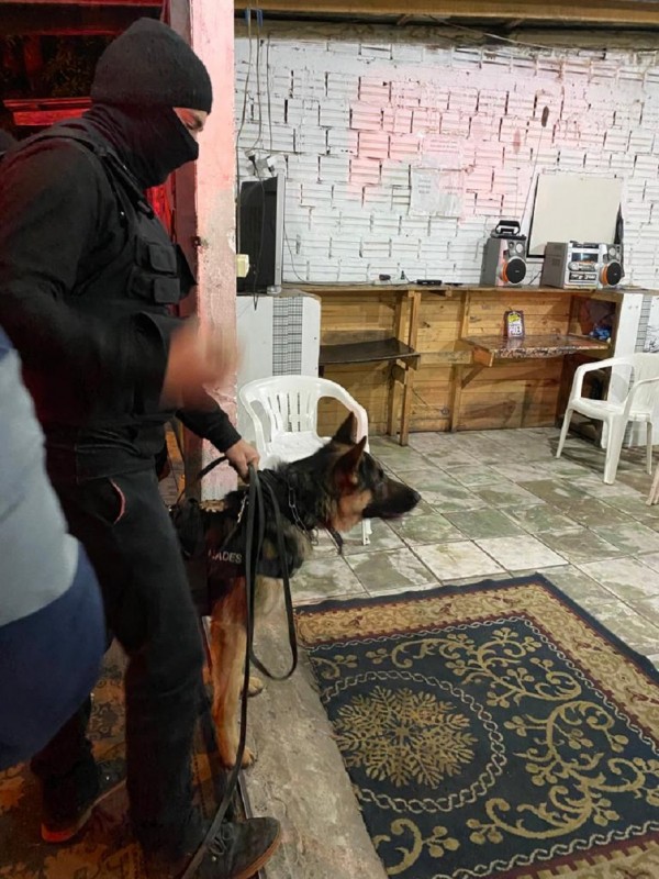 Policial civil segurando seu cachorro
