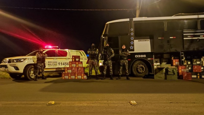 PMs da Força Tática do 8º BPM junto ao ônibus que transportava cerca de 200 caixas de bebidas alcoólicas, depositadas no bagageiro do coletivo