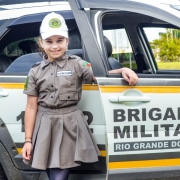 Menina tira foto ao lado da viatura da BM