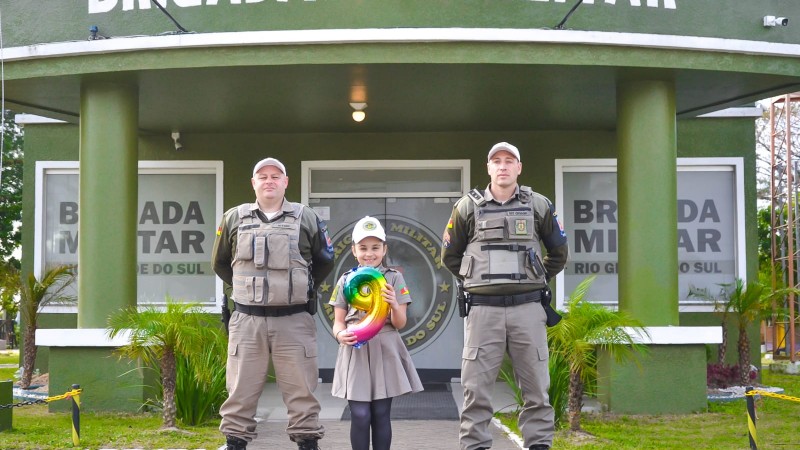 Menina tira foto com os policiais em frente ao quartel de Imbé