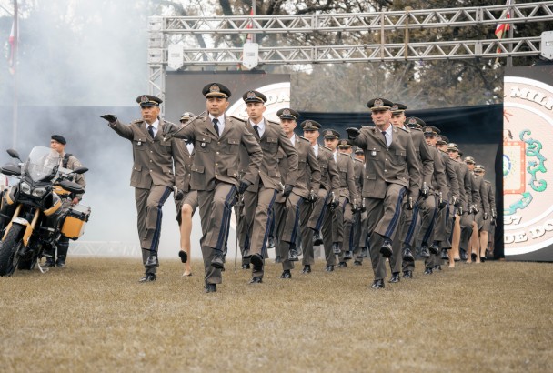 Os formandos entram no campo em formação de três colunas com o fardamento especial para a formatura.