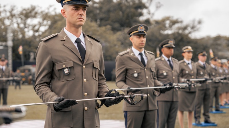 Os formandos seguram a espada deixada em frente ao corpo, momento em que o Padre Capelão da Brigada realiza a benção.