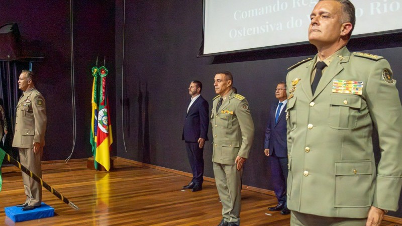 Foto mostra o momento da transmissão do comando, em que oficiais da BM estão perfilados em um palco