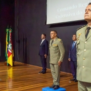 Foto mostra o momento da transmissão do comando, em que oficiais da BM estão perfilados em um palco