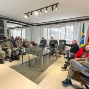 Policiais reunidos em círculo dialogando na sala do prédio da Polícia Civil
