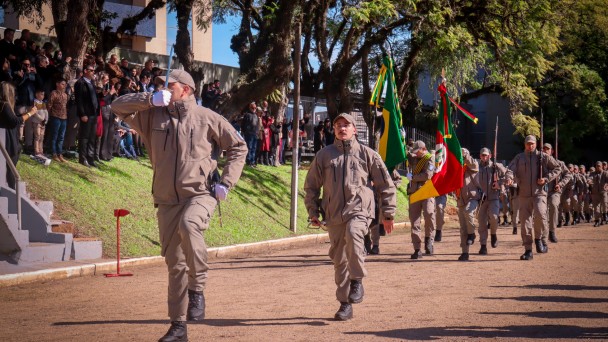 Foto mostra tropa desfilando em campo aberto em continência à maior autoridade presente
