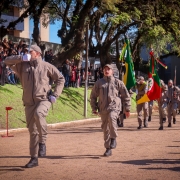 Foto mostra tropa desfilando em campo aberto em continência à maior autoridade presente