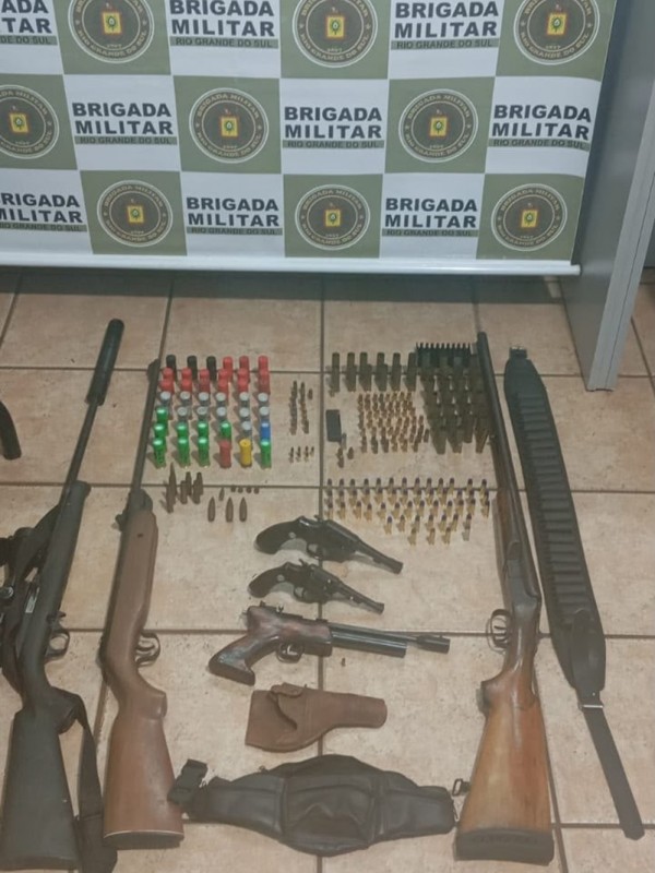 Apreens&otilde;es realizadas: muitas armas de fogo de cano longo dispostas, junto a muni&ccedil;&otilde;es, no ch&atilde;o.