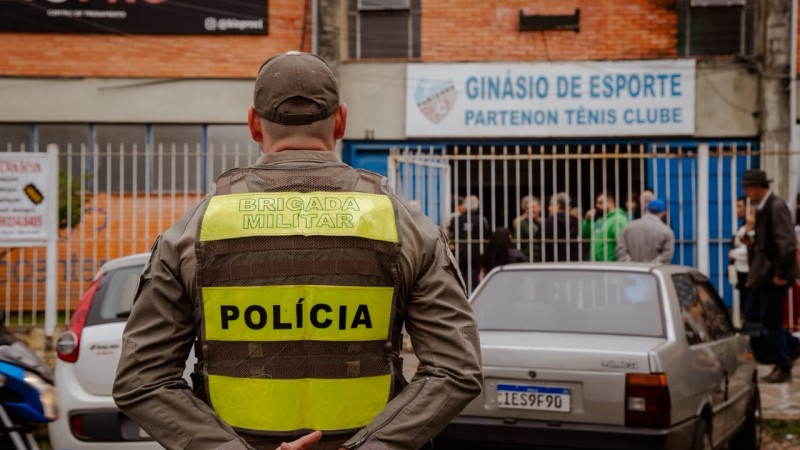 Foto mostra policial militar de costas em frente a um local de vota&ccedil;&atilde;o em Porto Alegre, o Partenon T&ecirc;nis Clube.